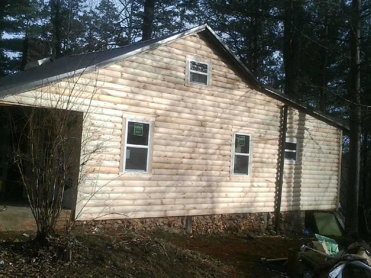 New log siding and dark metal roofing on a gable end in Mossyrock