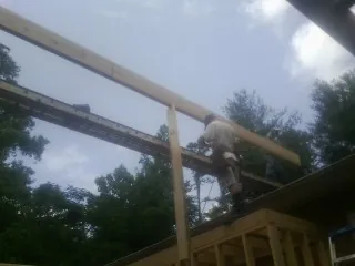 Carpenter setting a ridge beam over a new addition frame — Ice Dam Removal by Roofing Brothers in Mossyrock