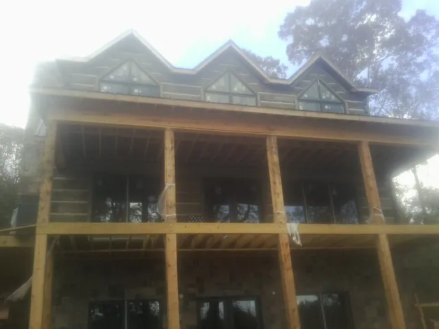 Dormers and porch framing on a large log home under construction — Roof Coating work by our crew in Mossyrock